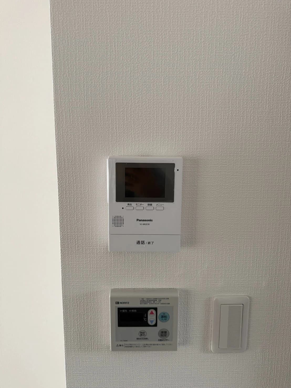 住戸の壁に取り付けたインターホンモニター、給湯リモコン、スイッチ